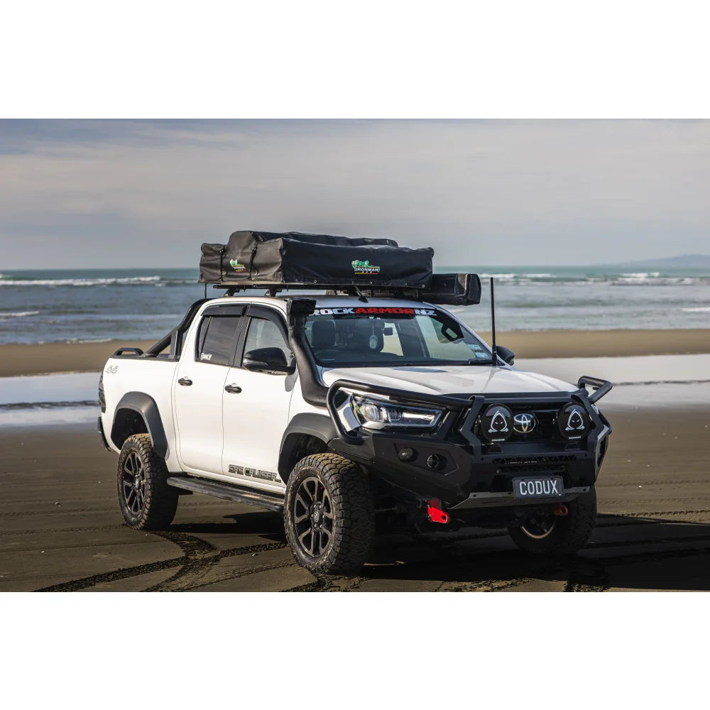 White Toyota Hilux pickup truck with steel hoop bull bar and driving lights for off-road driving