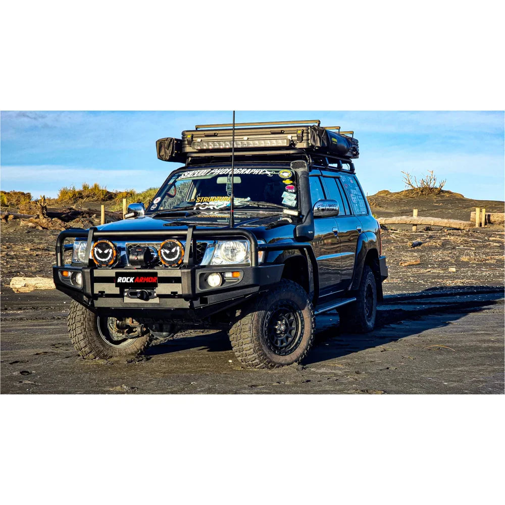 Black nissan patrol gu1 off-road vehicle equipped with rockarmor brushbar and roof rack for premium protection