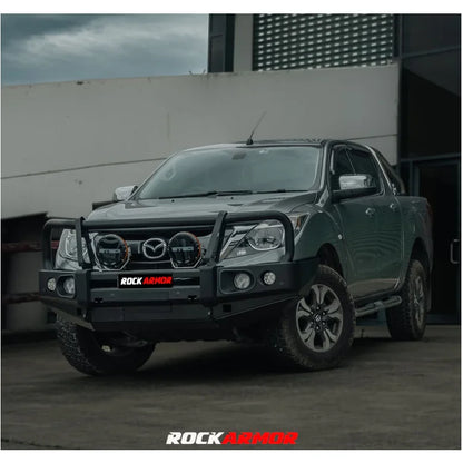 Gray mazda bt-50 pickup truck equipped with rockarmor elite steel hoop bullbar with winch compatible fog lights