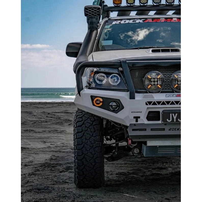 Modified white off-road Toyota Hilux N70 equipped with rockarmor GT hoop steel bullbar for frontal protection