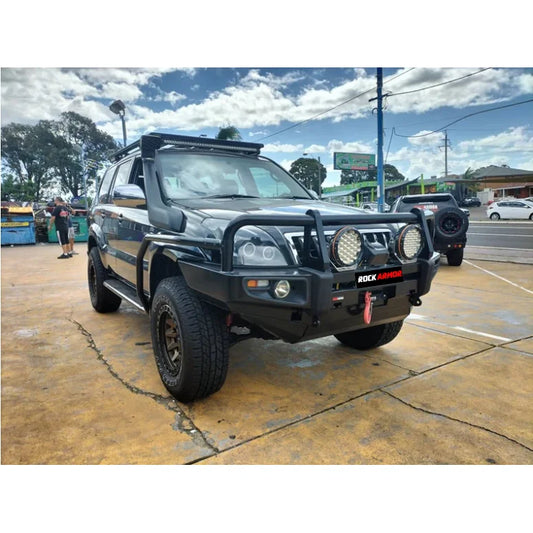 Black toyota prado fj120 with rockarmor premium steel bullbar featuring integrated led fog lights and roof rack