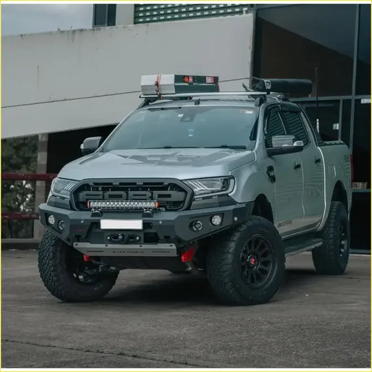 Silver ford ranger wildtrak with black off-road tires featuring rockarmor gt hoopless bullbar and rock sliders