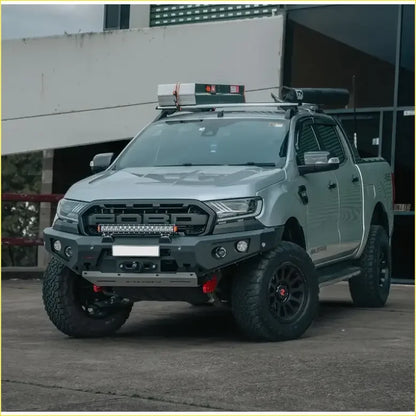 Silver ford ranger with black off-road tires and rugged front bumper featuring gt hoopless bullbar rock sliders