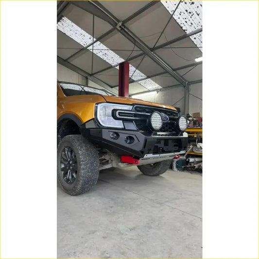 Black rugged front bumper with led lights and red tow hooks on yellow ford ranger from rockarmor rock pack