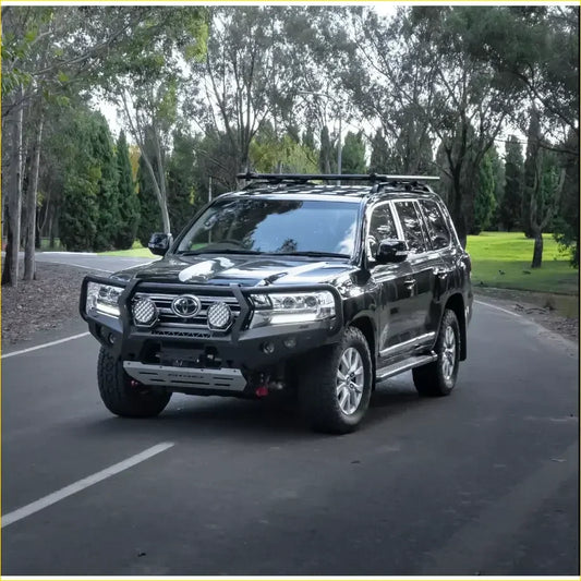 Black toyota land cruiser 300 with rockarmor gt hoop bullbar and rock sliders rugged front bumper and roof rack