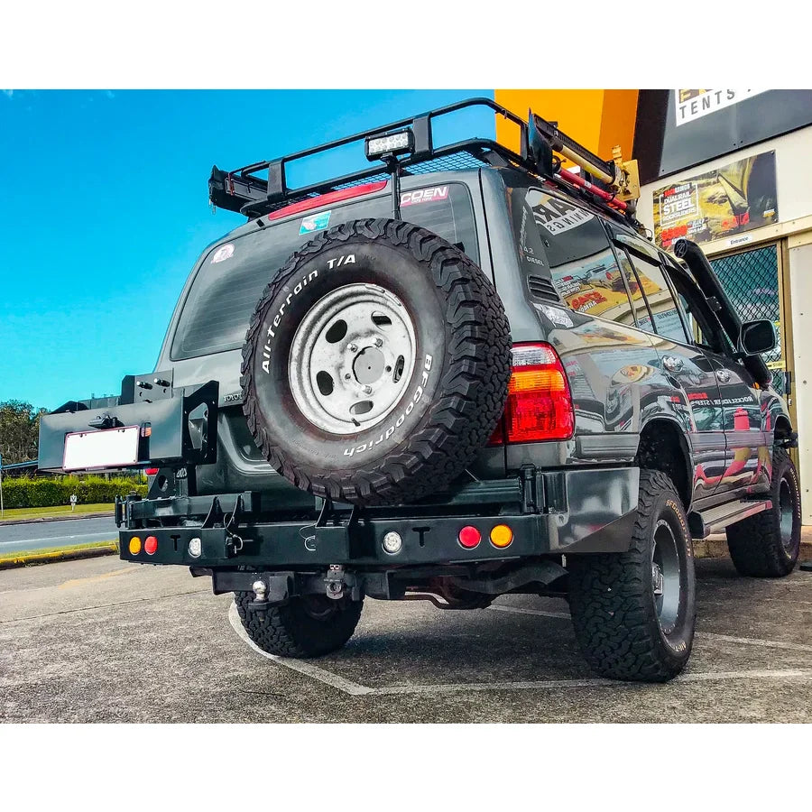Gray rockarmor steel dual wheel carrier mounted on the rear of a toyota landcruiser fj105 off-road vehicle