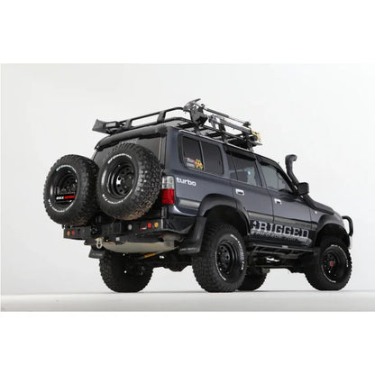 Dark gray rockarmor steel dual wheel carrier mounted on rear of toyota landcruiser fj80 1992-1997 with roof rack