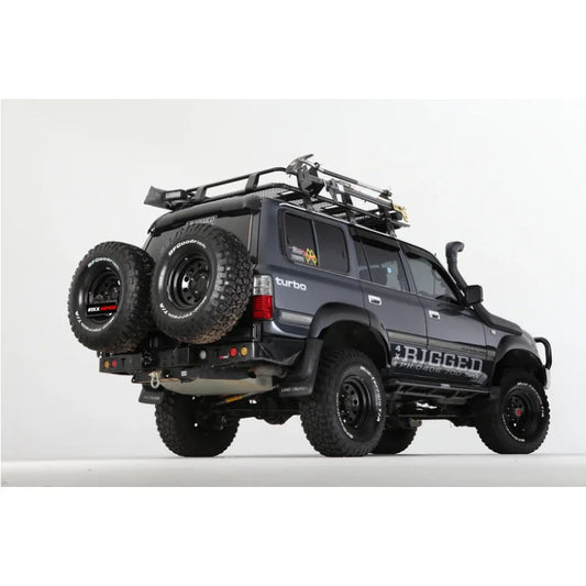 Dark gray rockarmor steel dual wheel carrier mounted on rear of toyota landcruiser fj80 1992-1997 with roof rack