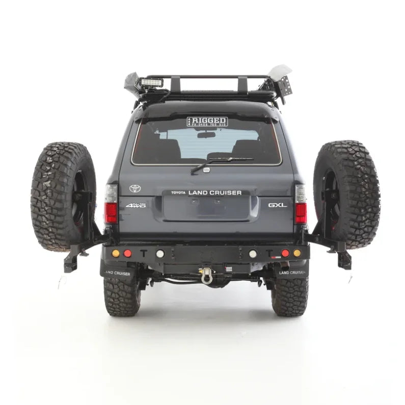 Gray rockarmor steel dual wheel carrier mounted on toyota landcruiser fj80 with dual spare tires rear view