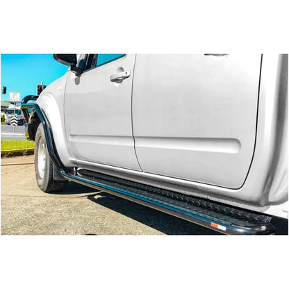 Silver Nissan Navara D40 with rockarmor steel rockslider side steps featuring black running boards and steel checker plate design