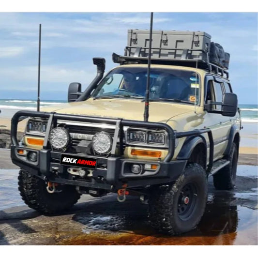 Modified tan toyota landcruiser fj80 with rockarmor premium steel bullbar and integrated led fog lights front view